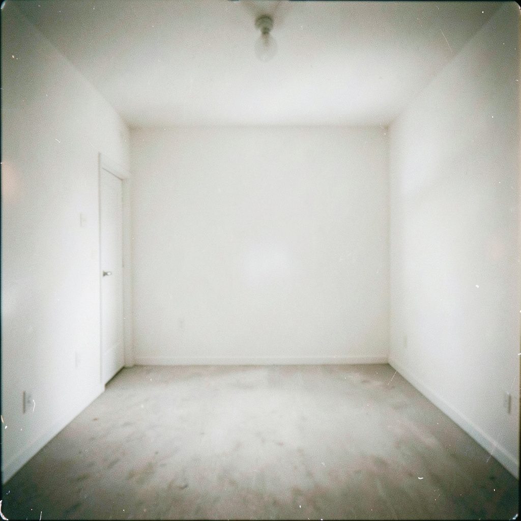 Bright white event room with tall windows and soft warm lighting, moody elegant atmosphere